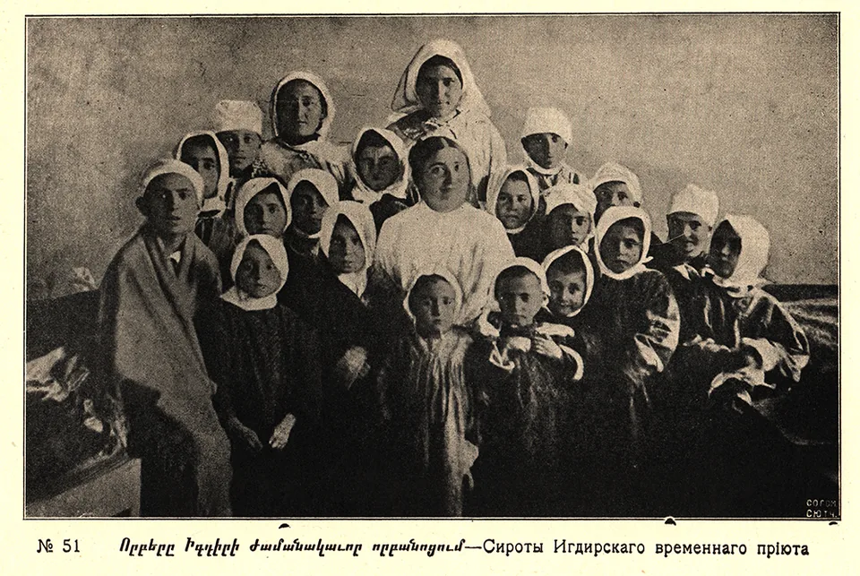 A group of children in headscarves poses for the camera indoors