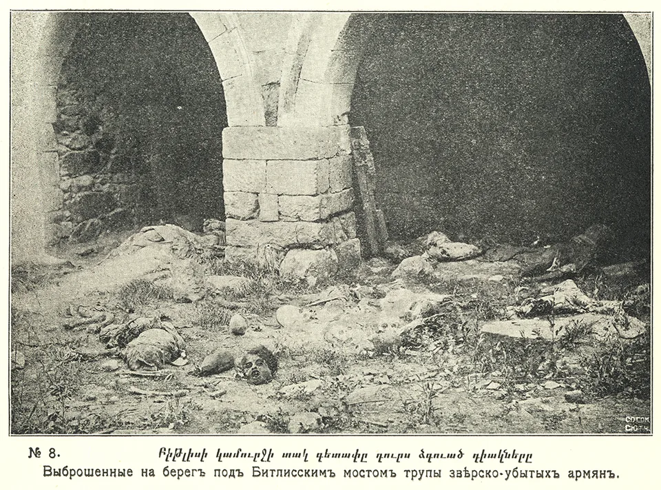 Human remains lie beside a stone pier of an arched bridge