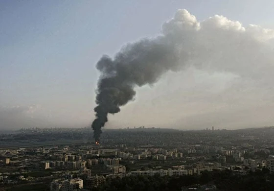 A tall column of dark smoke rises above Beirut.