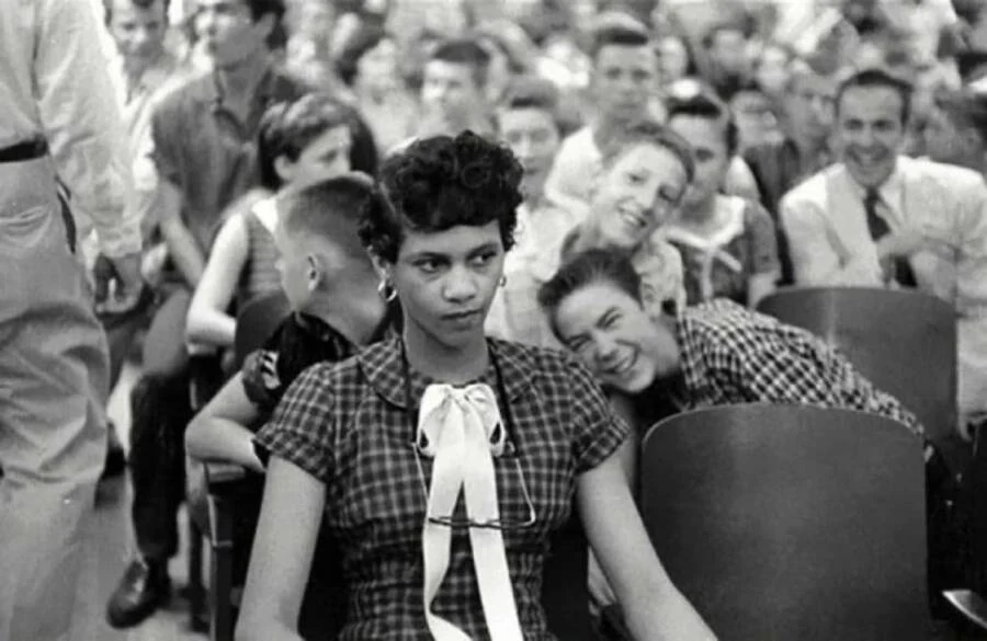 Dorothy Counts sits among Harding High pupils while a boy in a checked shirt leans towards her shoulder. Charlotte, 1957. Photographer unidentified; Charlotte Mecklenburg Library.