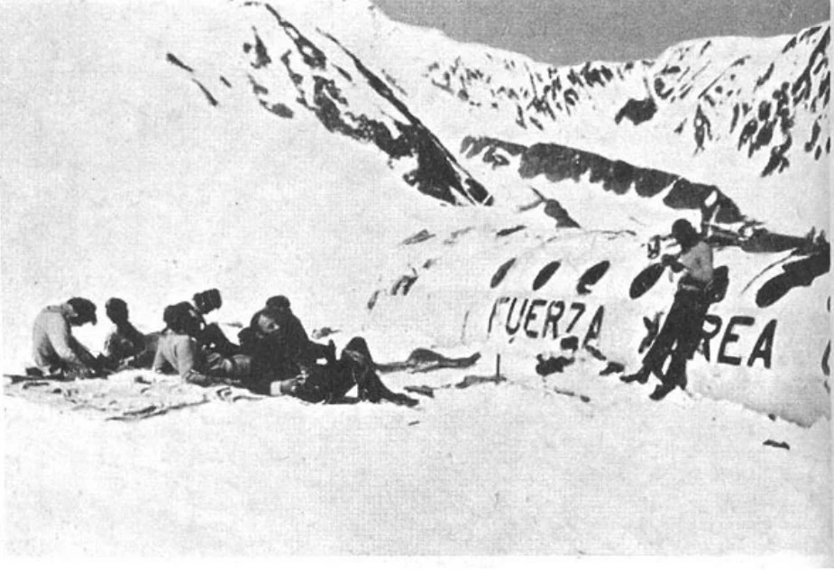 People stand in the snow near the fuselage, with Fuerza Aérea visible on its side. From a collection of pictures made by survivors; photographer and exact date unknown.