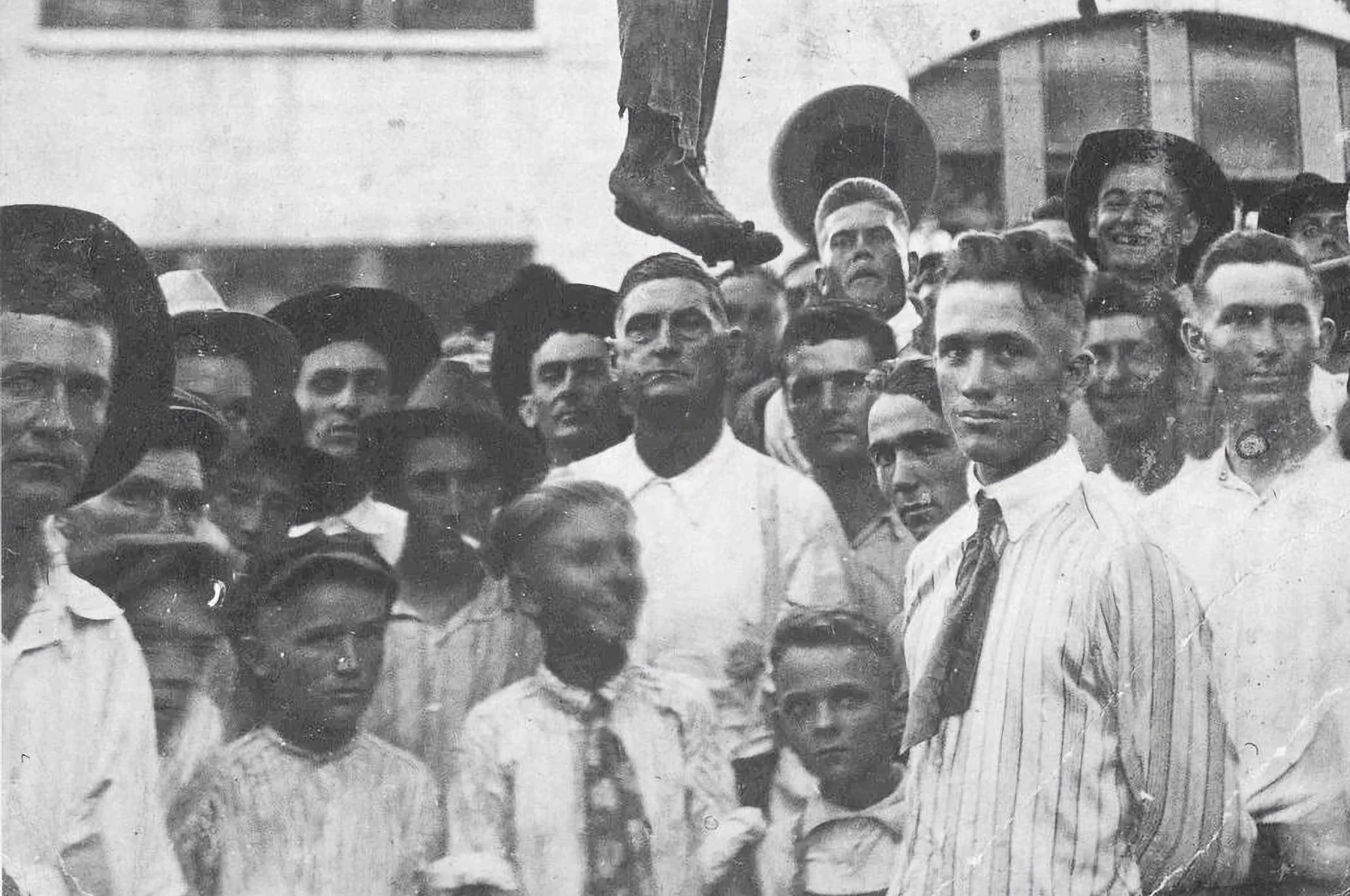 Фрагмент фотографии линчевания Лайджа Дэниелса: люди у дерева на площади в Сентере, Техас. 2 августа 1920 года.