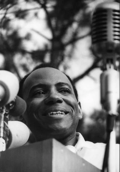 James Meredith speaks at a microphone before a crowd in Jackson