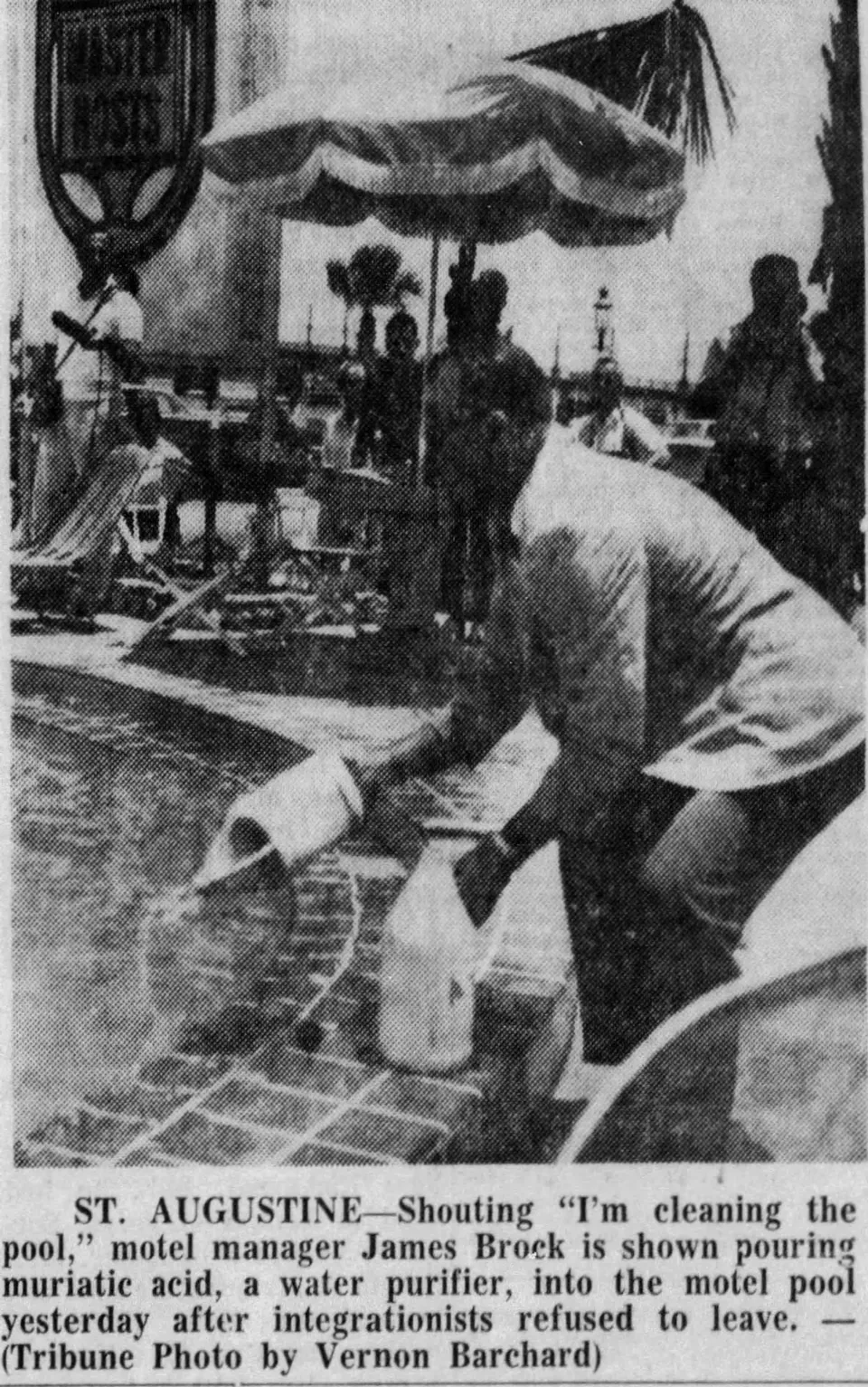 Newspaper photograph of a manager holding a container beside a pool, with its printed caption below