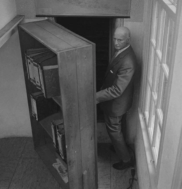 Отто Франк открывает книжный шкаф перед входом в убежище. Амстердам, июль 1964 года.