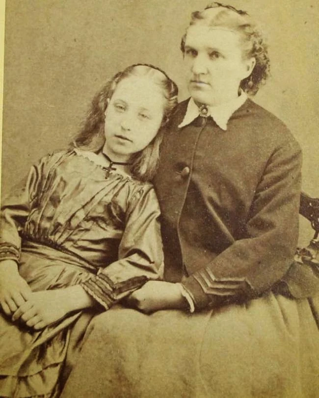 A young woman sits with her head inclined towards a woman beside her. The photograph circulates as post-mortem, but no catalogue record confirming the claim or identifying the women has been found.