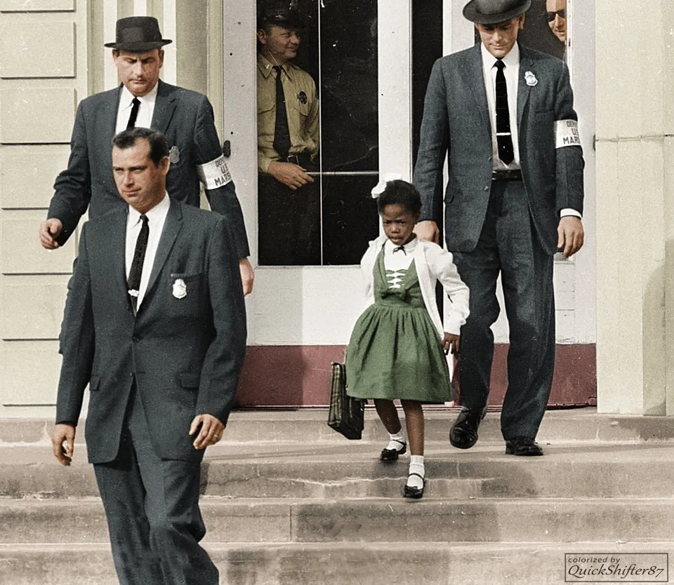 Digitally colourised version of Ruby Bridges leaving William Frantz Elementary School beside U.S. marshals