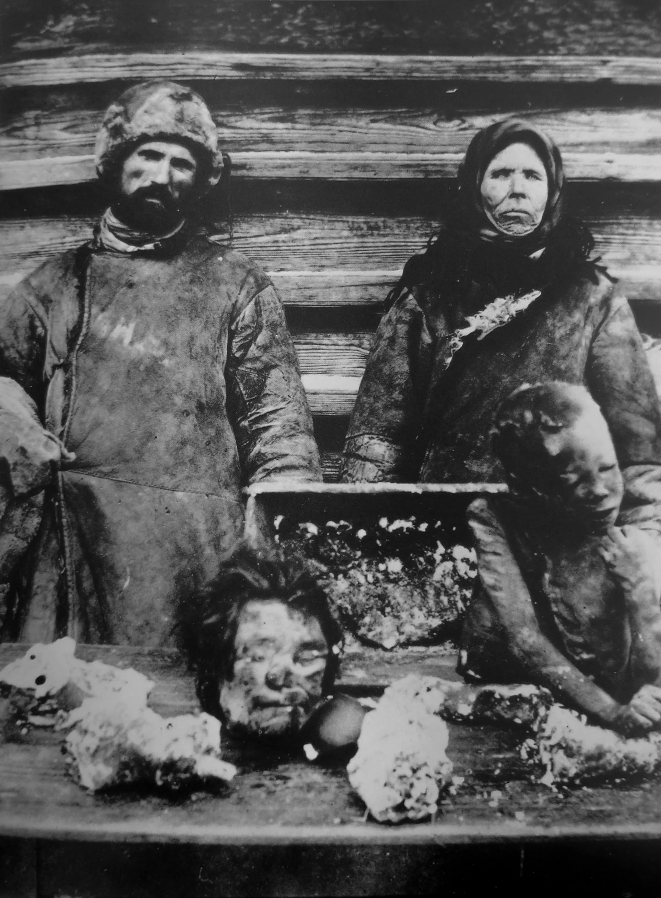 Two people behind a table with human remains. A later caption places the photograph in Samara province in 1921; identities and exact location are unknown.