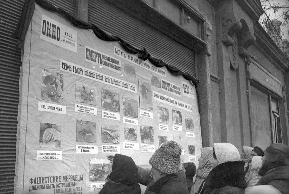 Люди рассматривают фотографии на стенде ТАСС.